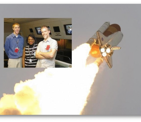 Space shuttle launching with two men posing in front of a model shuttle.