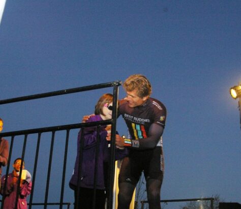 A child and an adult sharing a moment near a railing under a clear blue sky.