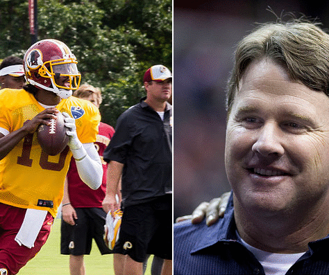 Football players practicing alongside a smiling coach in a stadium setting.