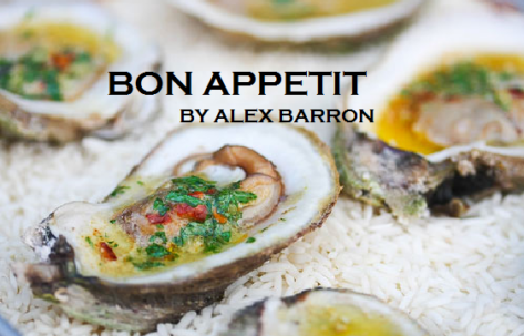 Close-up of fresh oysters on ice with vibrant garnish.