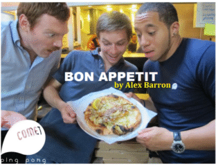 Three men excitedly admire a delicious plate of food in a cozy kitchen.