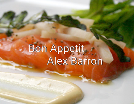 Close-up of a gourmet salmon dish with sauce and greens.