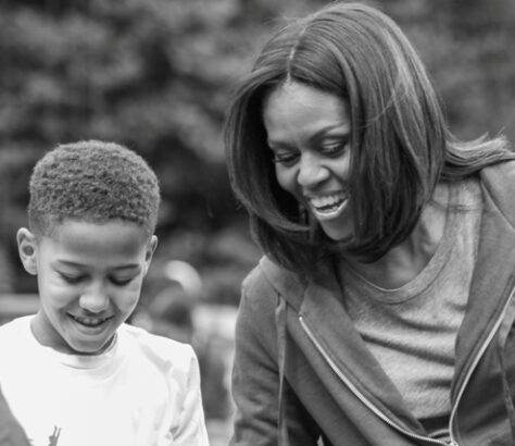 A joyful woman and boy sharing a moment outdoors.