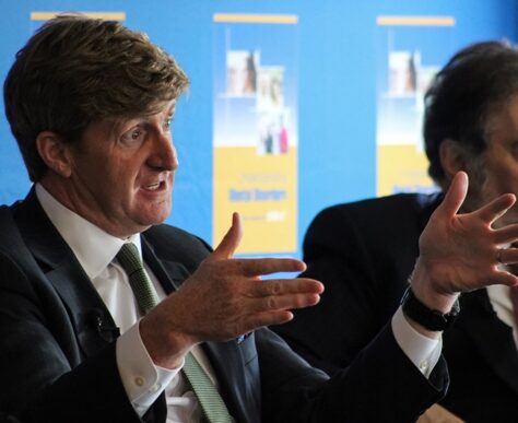 Two men in suits engaged in a serious discussion.