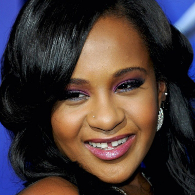 Smiling woman with flawless makeup and styled hair.