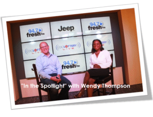 Two hosts sit in a radio studio for 'In the Spotlight' with Wendy Thompson.