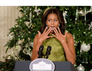 Michelle Obama surprised and joyful in front of a Christmas tree at the White House.