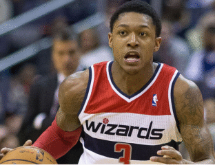 Basketball player in a Wizards jersey focused during a game.