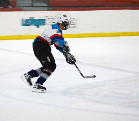 Ice hockey player skating and handling the puck on the rink.