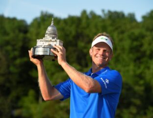 Golfer celebrating victory with a trophy in hand.