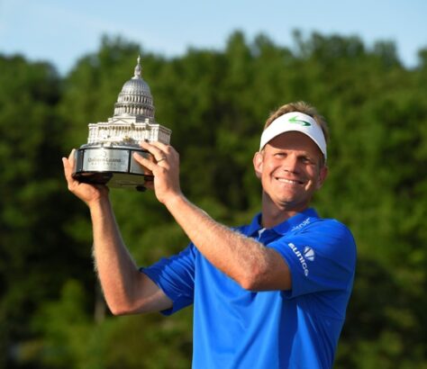 Golfer celebrating victory with a trophy in hand.