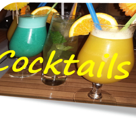Three colorful cocktails with orange garnishes and straws on a wooden table.