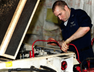 Technician connecting cables in an industrial machine.