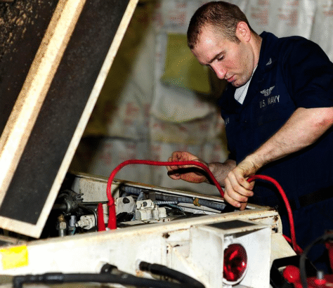 Technician connecting cables in an industrial machine.