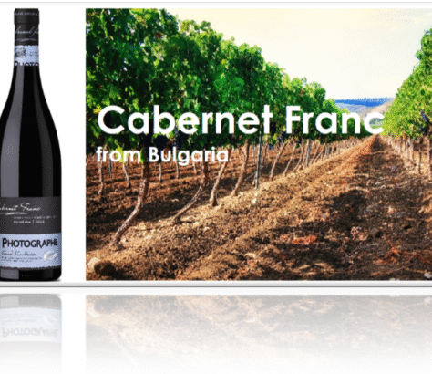 Bottle of Cabernet Franc wine from Bulgaria with vineyard background.