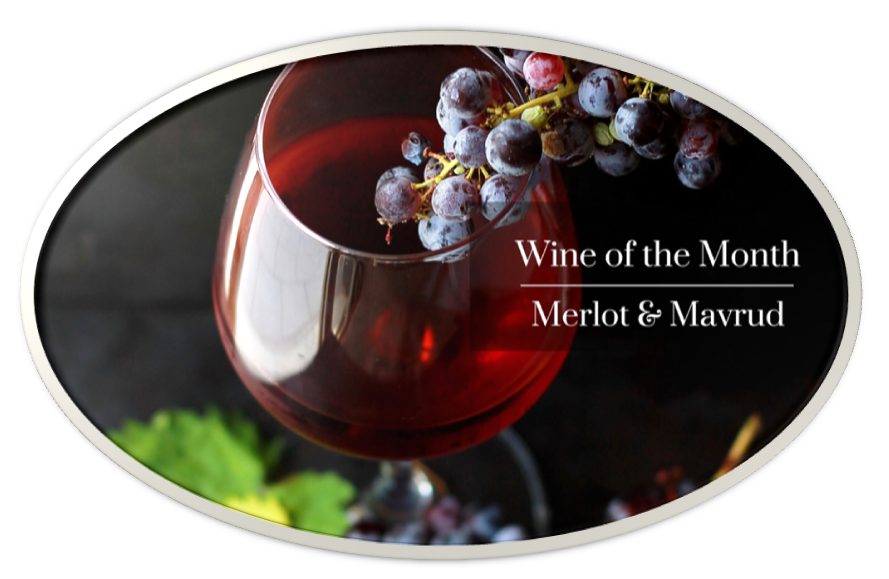 A glass of red wine with grapes, highlighting Merlot and Mav wine varieties.