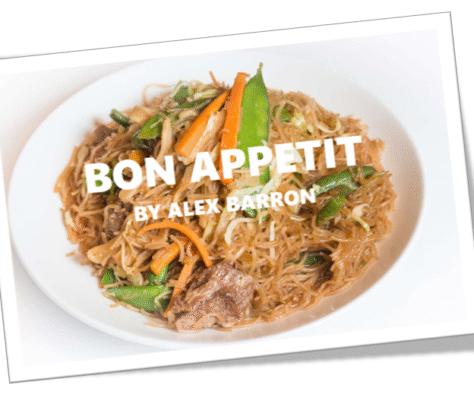A hearty dish of pulled meat with fresh carrots and herbs.