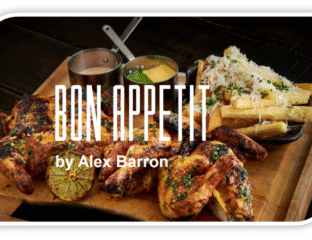 Delicious grilled chicken served with rice, fries, and sauces on a wooden platter.