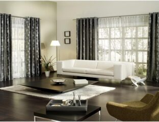 Modern living room with white sofa and dark curtains.