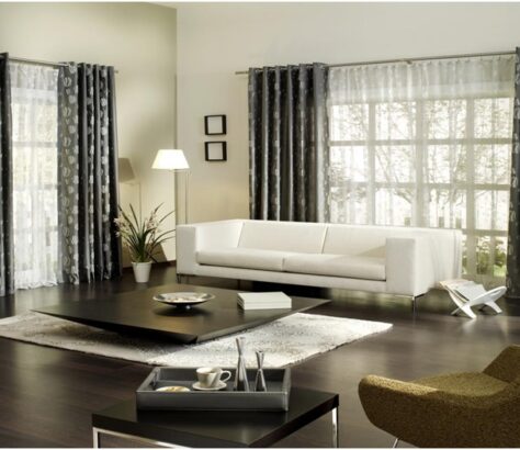 Modern living room with white sofa and dark curtains.