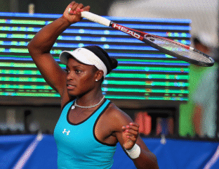 Female tennis player in action, preparing to hit a backhand shot.