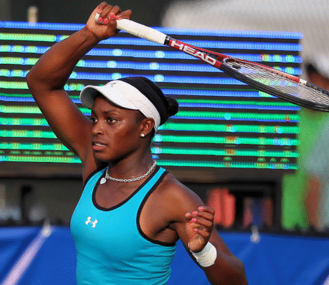 Female tennis player in action, preparing to hit a backhand shot.