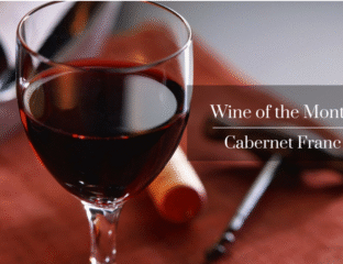 Close-up of a glass of red Cabernet Sauvignon wine with cork and opener.