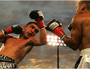 Two boxers in an intense match as one throws a punch.