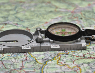 A compass resting on a detailed map for navigation.