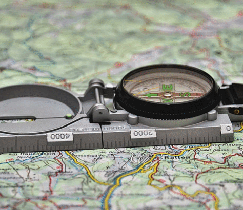 A compass resting on a detailed map for navigation.