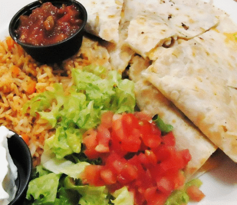 A plate with quesadilla, salsa, rice, lettuce, and diced tomatoes.