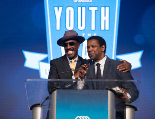 Two men speaking and smiling at a podium during an event.