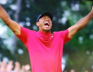 Tiger Woods celebrating a golf victory with arms raised.