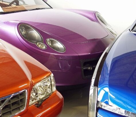 Close-up of three colorful luxury sports cars parked side by side.
