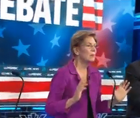 A woman speaking passionately during a televised debate with patriotic American imagery.