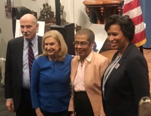 Four diverse professionals posing together indoors.