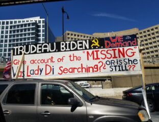 Protesters display a sign accusing Biden of covering up missing persons.