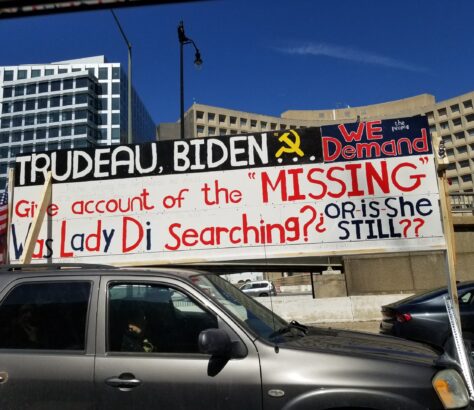 Protesters display a sign accusing Biden of covering up missing persons.