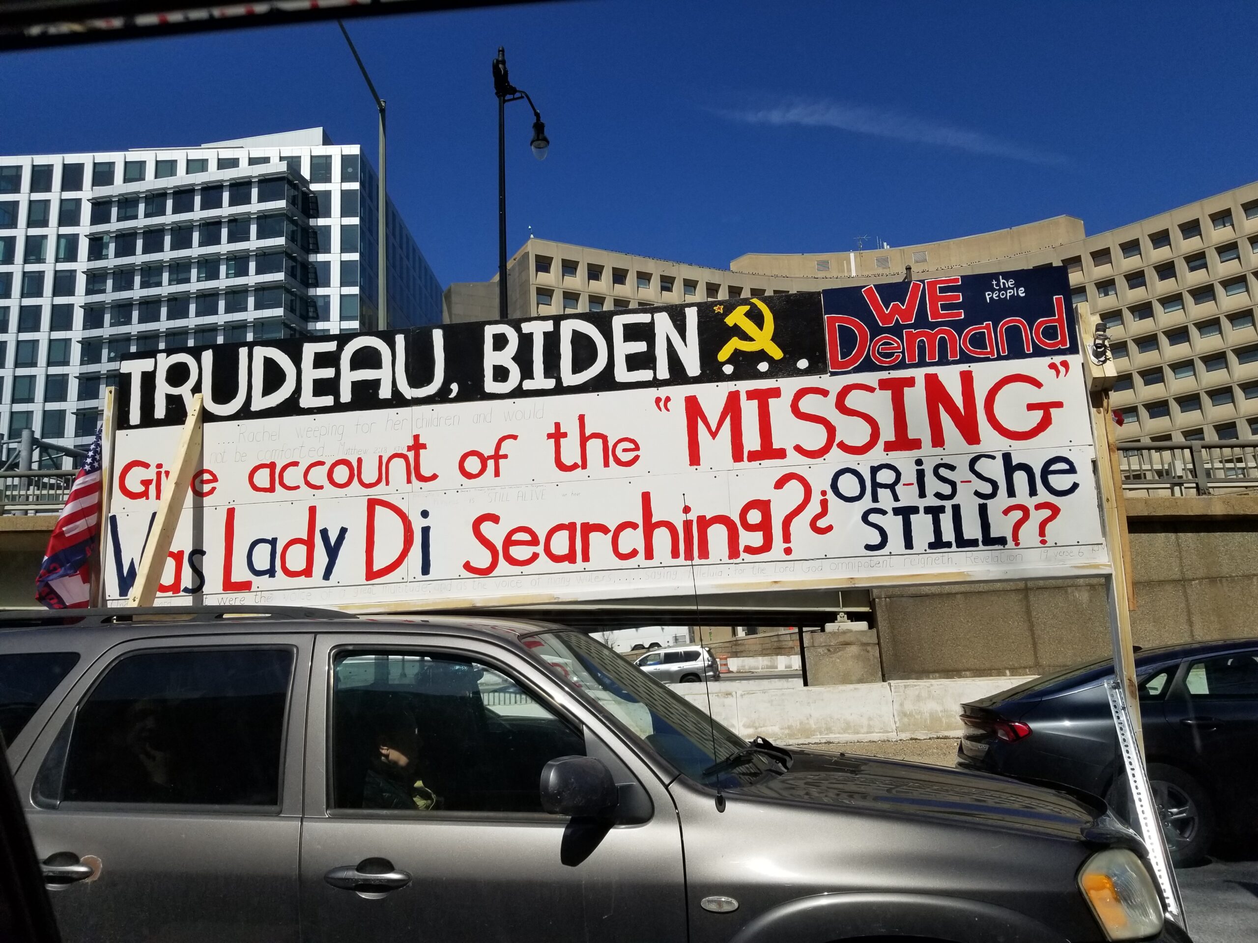 Protesters display a sign accusing Biden of covering up missing persons.