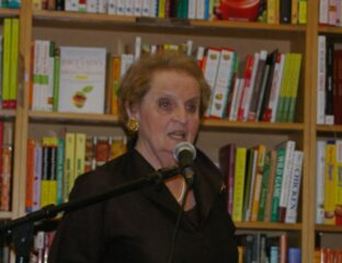 Woman speaking into a microphone at a bookstore event.