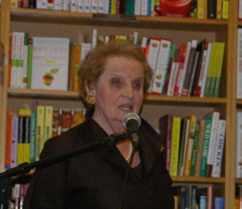 Woman speaking into a microphone at a bookstore event.