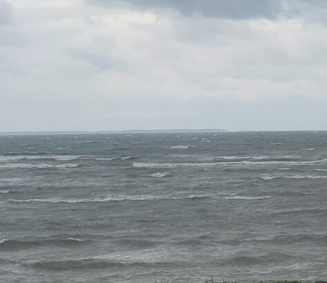 Choppy ocean waves under a cloudy sky.