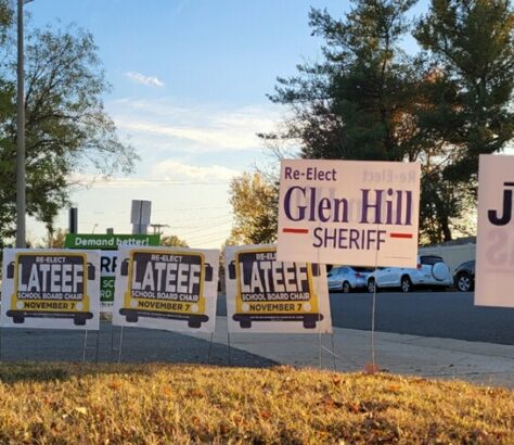Yard signs for political candidates Glen Hill and Latee in a residential area.