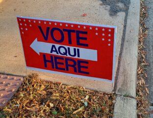 Sign directing voters to the polling place in Spanish and English.