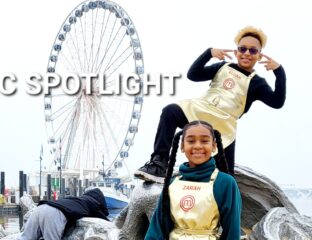 Two cheerful performers in front of a large Ferris wheel.