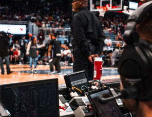 Close-up of basketball game equipment and staff during warm-up.