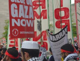 Protesters hold red banners demanding an end to the Gaza siege.