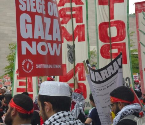 Protesters hold red banners demanding an end to the Gaza siege.