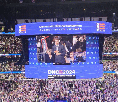Speaker addressing a large crowd at the Democratic National Convention 2024.