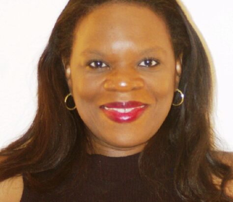 Smiling woman with long dark hair and red lipstick.